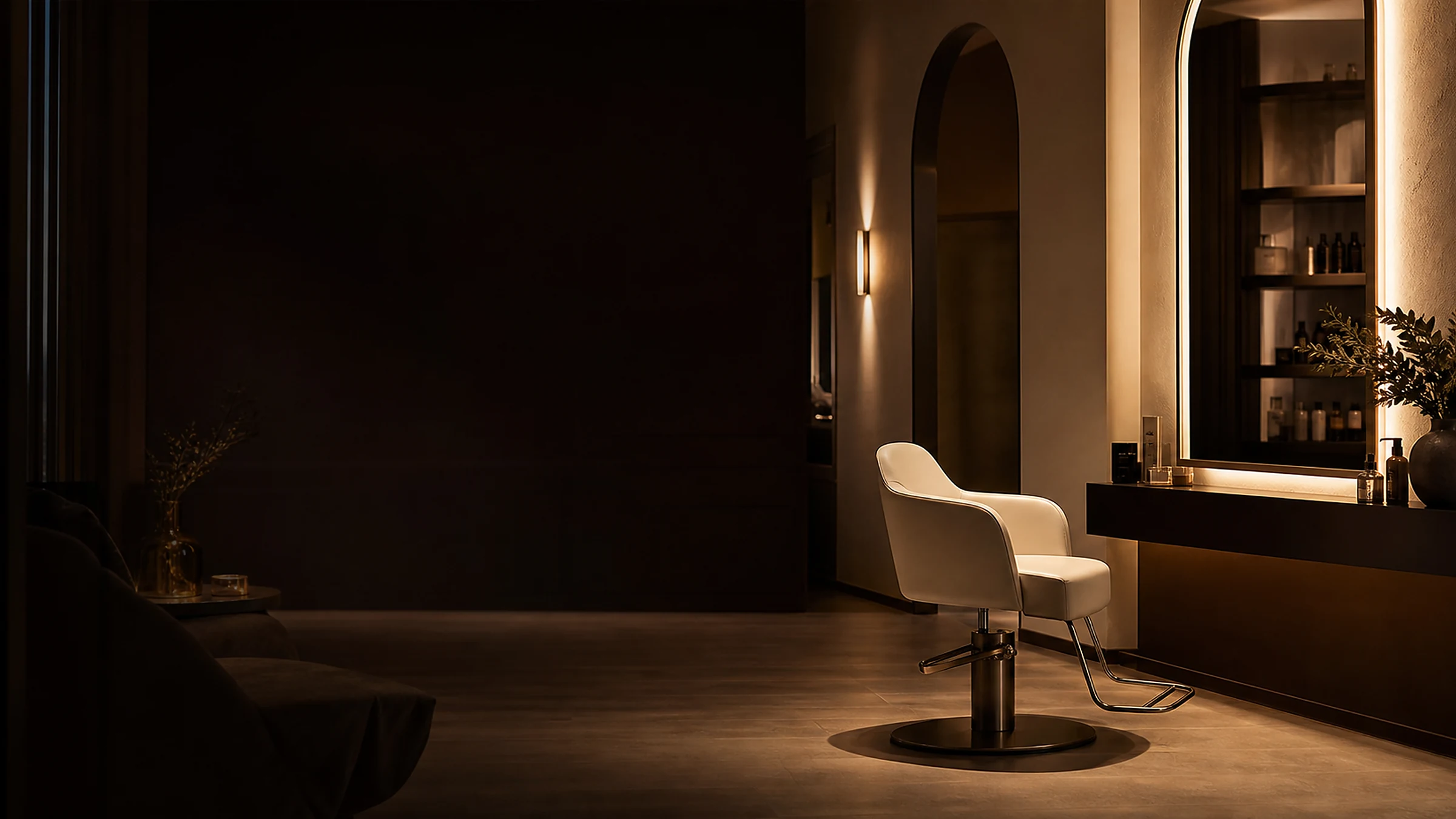 A quiet salon after closing, with one empty styling chair in warm light.