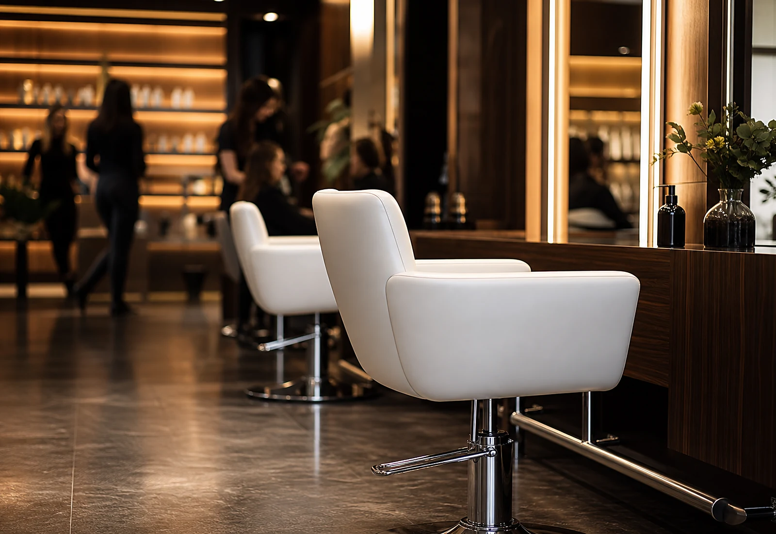 A busy salon with one empty styling chair in the foreground.