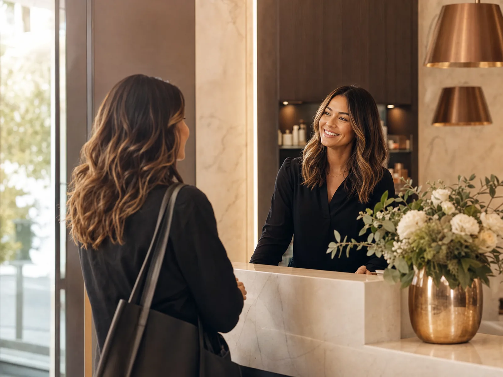 A returning client warmly welcomed at the salon reception.